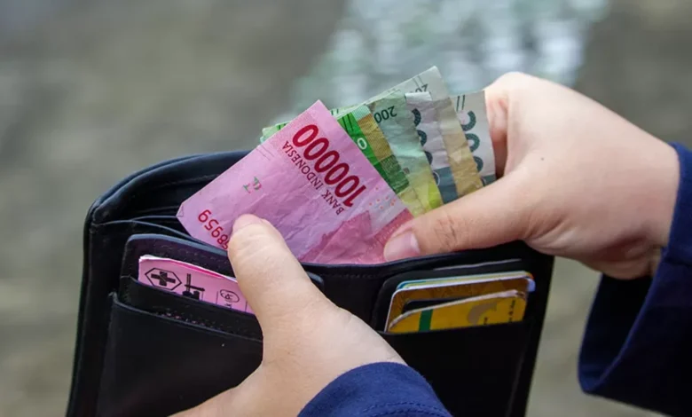 Ilustrasi mengambil uang dalam dompet tips mengatur keuangan setelah lebaran