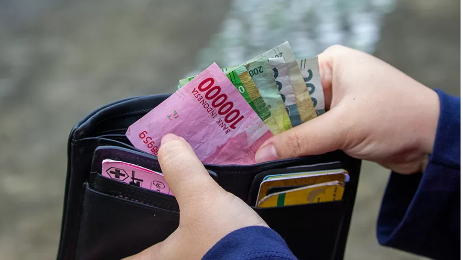 Ilustrasi mengambil uang dalam dompet tips mengatur keuangan setelah lebaran