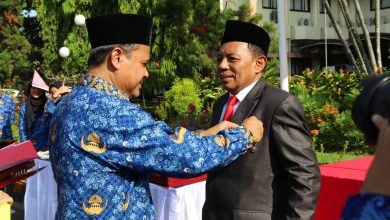 Rektor Unram, Prof. Ir. Bambang Hari Kusumo, M.Agr.St., Ph.D., memasangkan Satyalancana Karya Satya kepada Iwan Harsono.