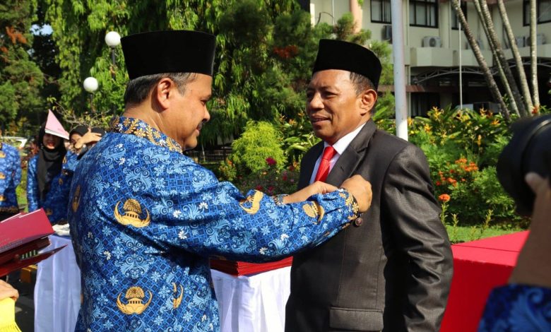 Rektor Unram, Prof. Ir. Bambang Hari Kusumo, M.Agr.St., Ph.D., memasangkan Satyalancana Karya Satya kepada Iwan Harsono.