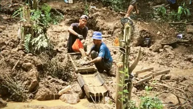 Dua penambang yang mendulang di aliran air sungai Gunung Kongbawi