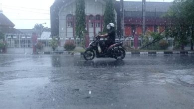 Pengendara motor di Kota Mataram yang berkendara saat hujan.