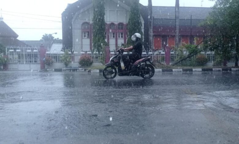 Pengendara motor di Kota Mataram yang berkendara saat hujan.
