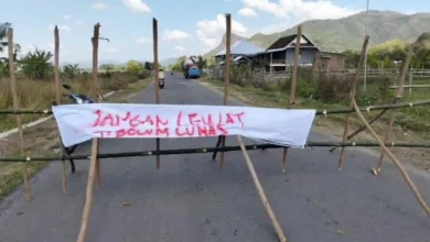 Pagar bambu dan spanduk protes membentang menutupi ruas Jalan Baru Lamusung-Senayan, Kabupaten Sumbawa Barat, Rabu, 22 Juli 2026.