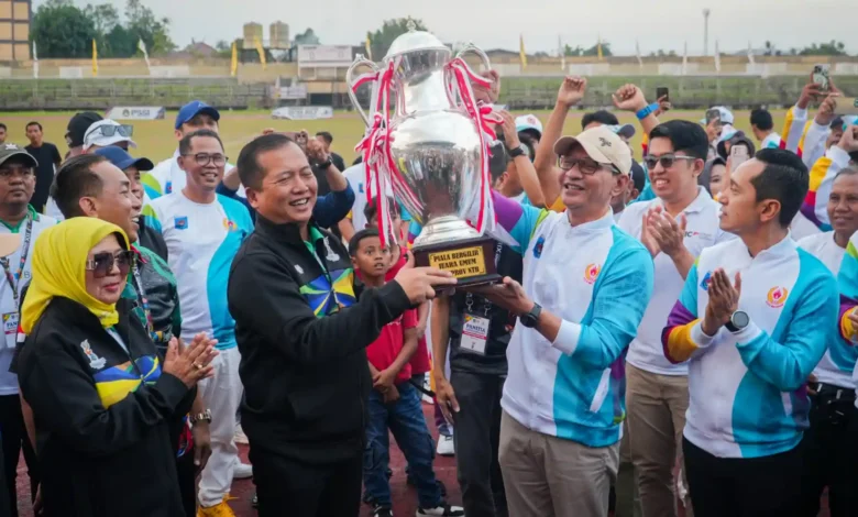 Wali Kota Mataram, Mohan Roliskana (kanan) mengangkat Piala Bergilir Juara Porprov NTB pada penutupan Porprov di GOR Turida, Sabtu, 25 Juli 2026.