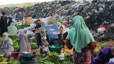 Aktivitas jual-beli di Pasar Gunungsari dengan latar belakang tumpukan sampah yang menggunung. Sejumlah pedagang harus menutup hidung akibat bau menyengat dari sampah, Selasa, 7 Juli 2026.