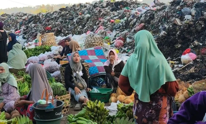 Aktivitas jual-beli di Pasar Gunungsari dengan latar belakang tumpukan sampah yang menggunung. Sejumlah pedagang harus menutup hidung akibat bau menyengat dari sampah, Selasa, 7 Juli 2026.