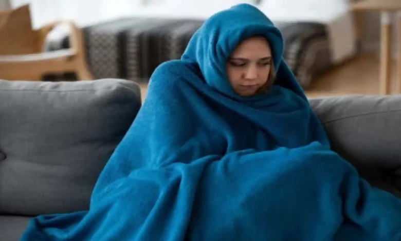 Ilustrasi wanita yang memakai selimut karena kedinginan di tengah perubahan suhu di NTB.