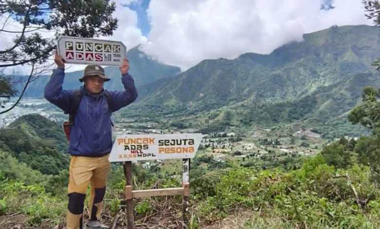 Seorang pendaki lokal berada di puncak bukit terbaru Sembalun yakni Bukit Adas, Juli 2026.