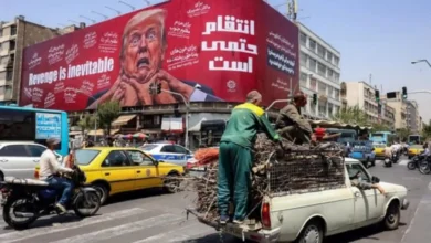 Para pengendara mobil melintas di depan papan reklame besar yang menjanjikan pembalasan terhadap Presiden AS Donald Trump di sepanjang Jalan Jomhouri di pusat Teheran, Iran.