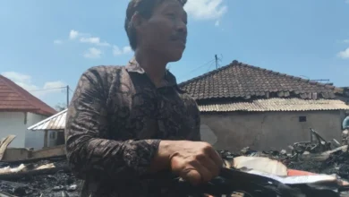 Warga Desa Sade, Marwan (55), mencari sisa-sisa naskah lontar kuno yang terbakar bersama rumahnya, Minggu, 23 Agustus 2026.