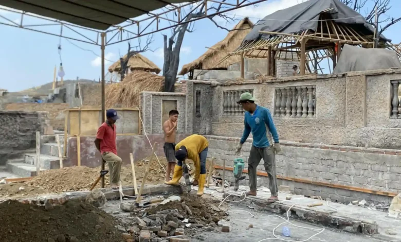 Empat warga desa Adat Sade tampak mencampur semen dan pasir untuk jadi bahan pembuatan dasar rumah mereka, Minggu, 27 September 2026.