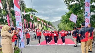 Bupati Sumbawa Barat, H. Amar Nurmansyah, memegang bendera pelepasan saat melepas peserta Lomba Gerak Jalan Tepat Waktu KSB di garis start, Taliwang, Senin, 7 September 2026.