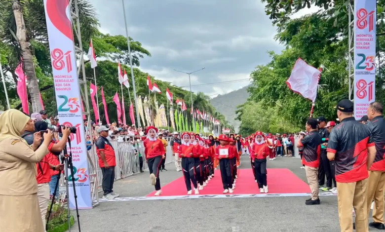 Bupati Sumbawa Barat, H. Amar Nurmansyah, memegang bendera pelepasan saat melepas peserta Lomba Gerak Jalan Tepat Waktu KSB di garis start, Taliwang, Senin, 7 September 2026.