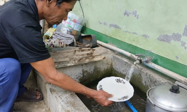 Warga Dusun Bongor Induk, Tanwir, menunjukkan air sumurnya yang berbau menyengat dan berwarna kekuningan, Selasa, 8 September 2026.