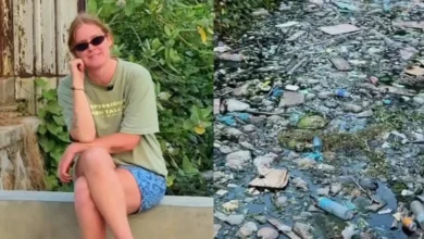 Seorang turis saat memperlihatkan kondisi salah satu saluran air di wilayah Kuta Mandalika yang penuh dengan sampah.
