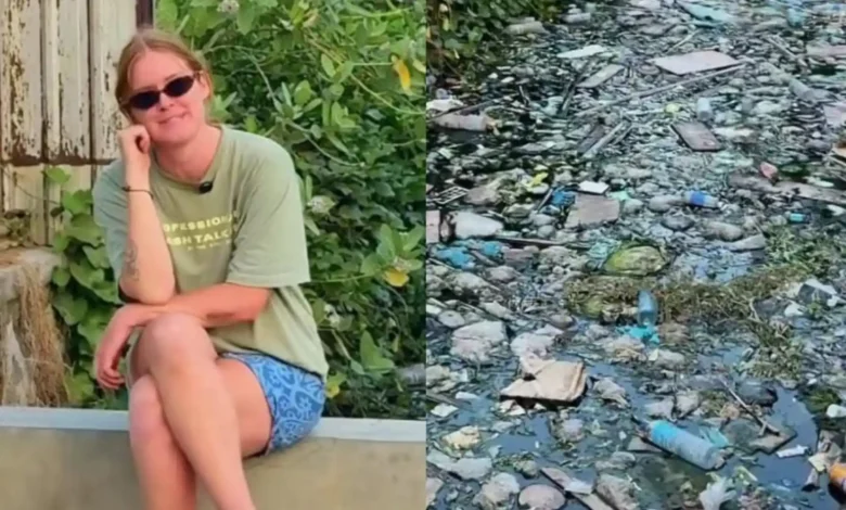 Seorang turis saat memperlihatkan kondisi salah satu saluran air di wilayah Kuta Mandalika yang penuh dengan sampah.