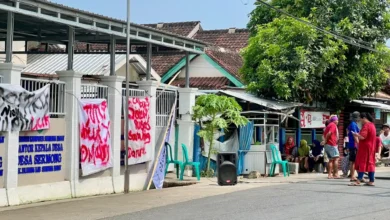 Suasana aksi penyegelan Kantor Desa Sermong oleh massa yang membentangkan spanduk protes atas dugaan kecurangan hasil Pilkades berbasis e-voting, Senin, 26 Oktober 2026.