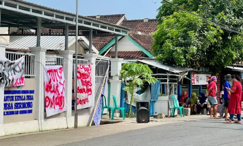 Suasana aksi penyegelan Kantor Desa Sermong oleh massa yang membentangkan spanduk protes atas dugaan kecurangan hasil Pilkades berbasis e-voting, Senin, 26 Oktober 2026.