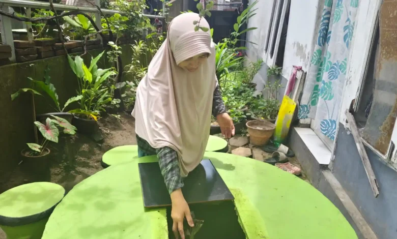 Warga Lingkungan Marong, Karang Tatah, Megawati memperlihatkan Tempah Dedoro, Inovasi pembuangan sampah Ramah Lingkungan di halaman rumahnya.