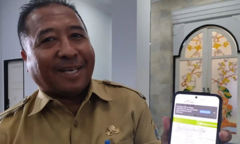 Inspektur Inspektorat Lobar, Suparlan, tersenyum saat menunjukkan bukti pelunasan temuan dana Desa Senggigi, Senin, 5 Oktober 2026.